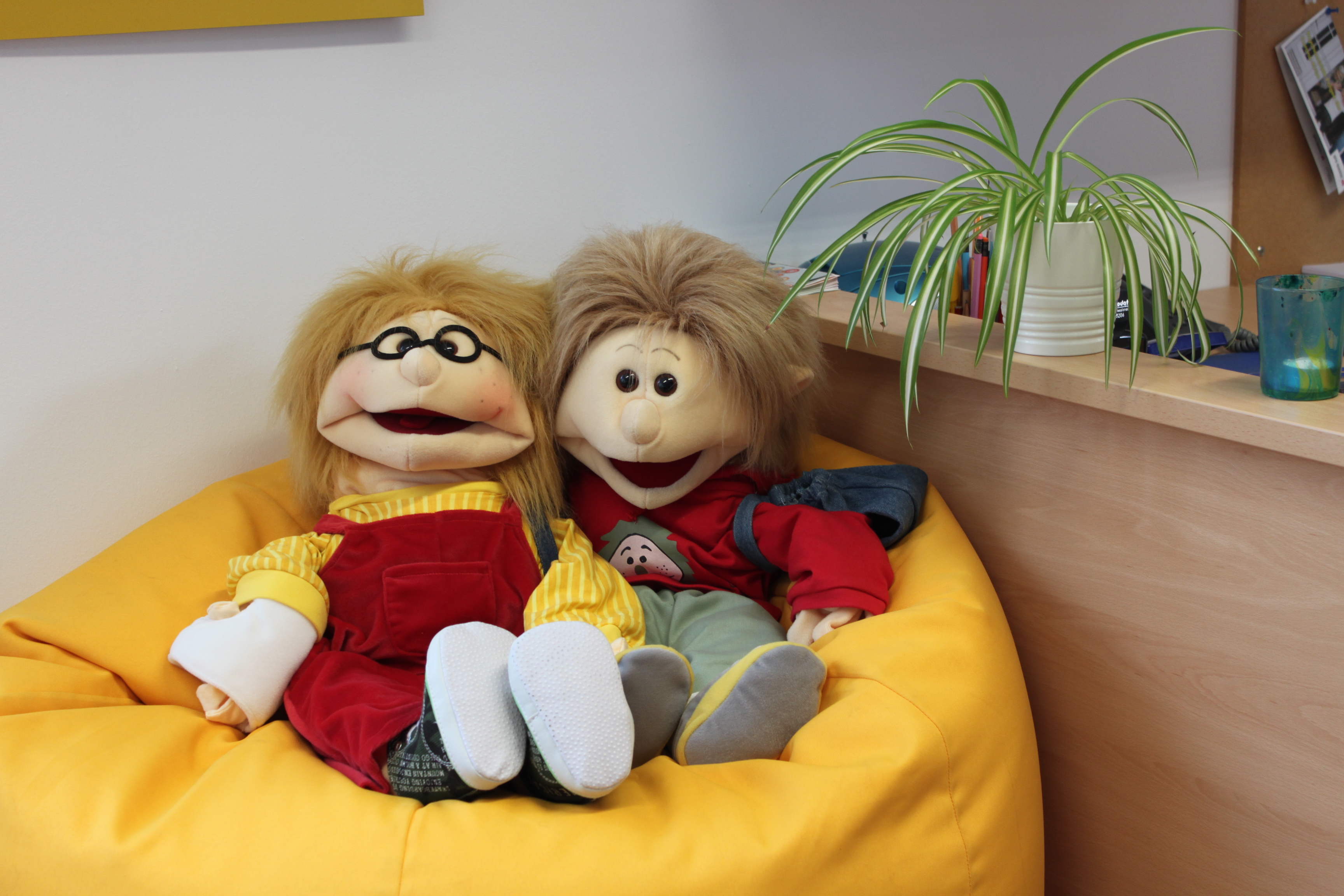 2 Puppen auf einer Sitzsack in einem Büro