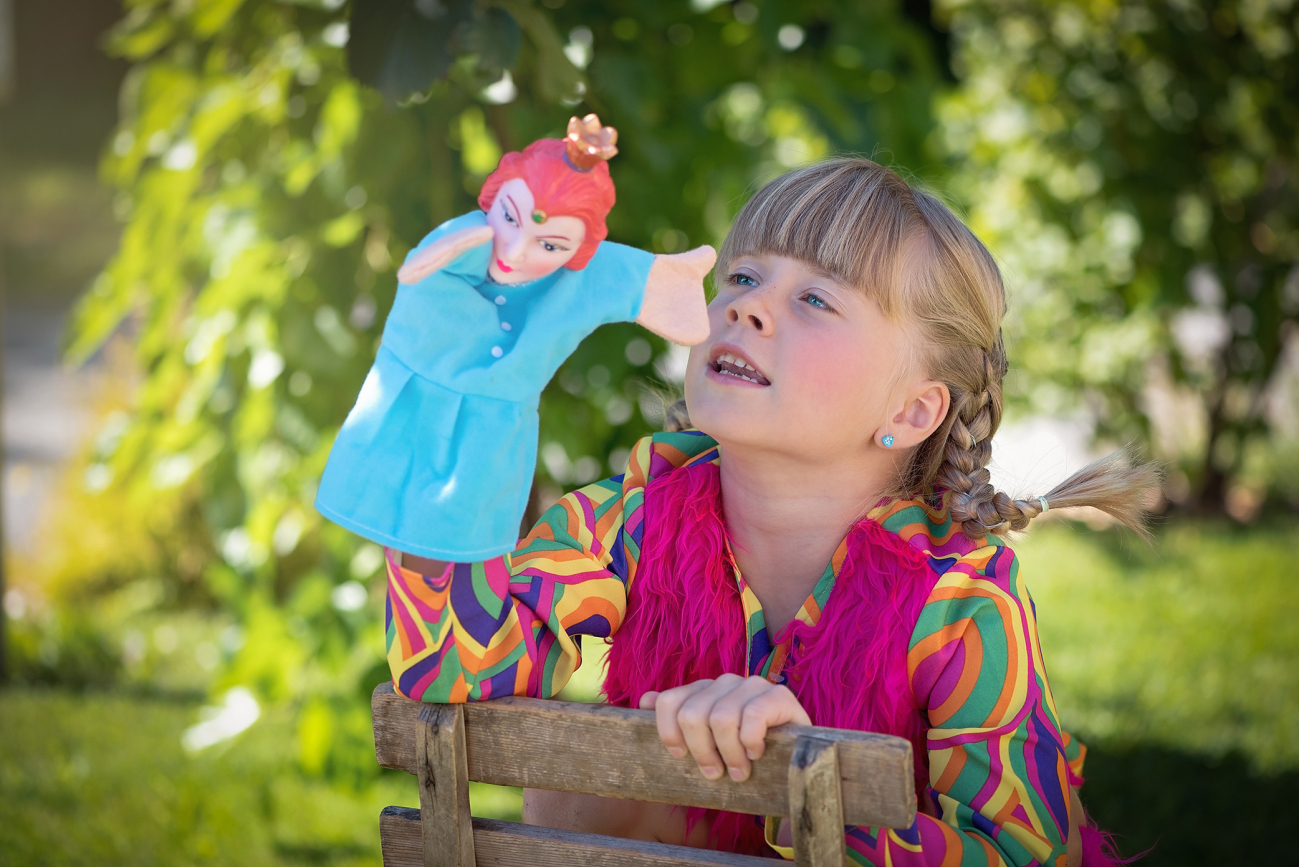 Mädchen, das mit einer Handpuppe spielt.