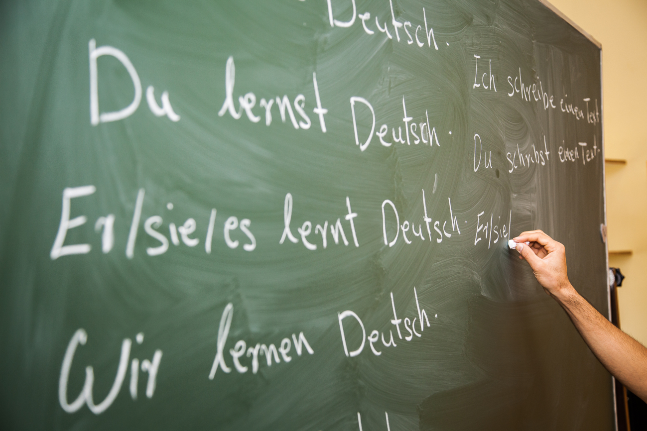 Im Deutschkurs im BACH Bildungszentrum schreibt jemand an die Tafel: Er/sie/es lernt Deutsch