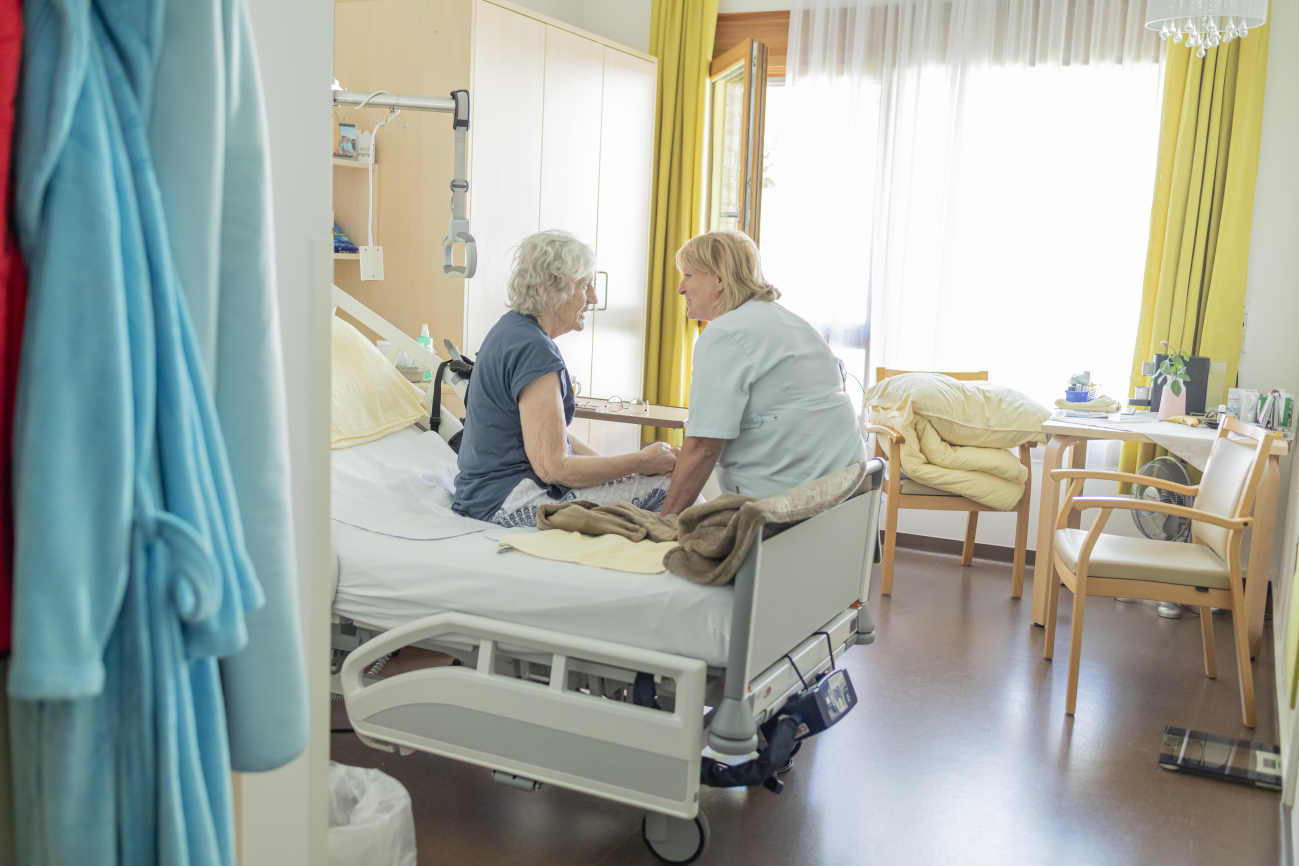 Die Pflegedienstleitung des Diakonie Hospiz Treffen im Gespräch mit einer Dame, die im Hospiz lebt