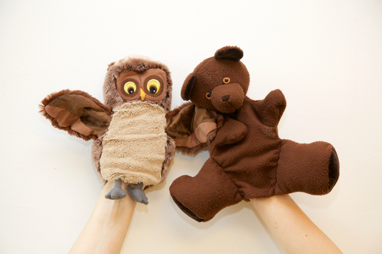 Eine Eulen-Handpuppe und eine Teddybär-Handpuppe wirken traurig