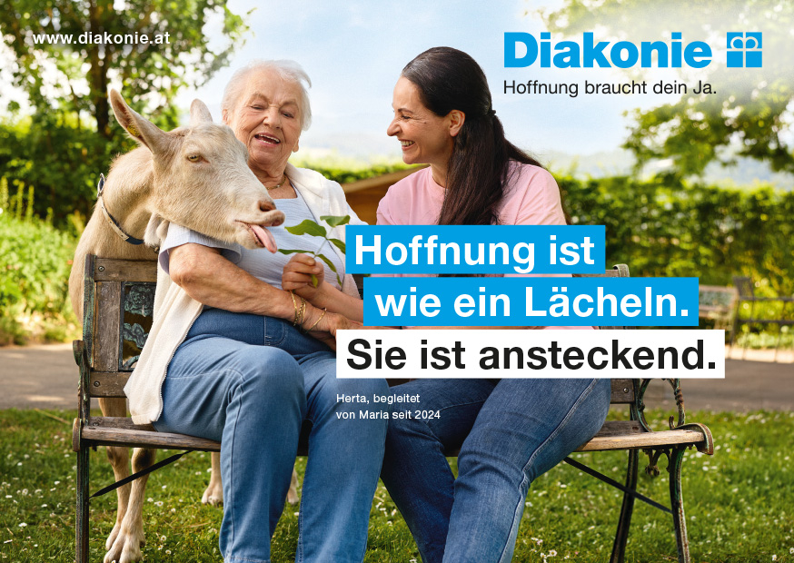 Zwei Frauen sitzen auf einer Parkbank und unterhalten sich, während sie gemeinsam eine Ziege füttern.