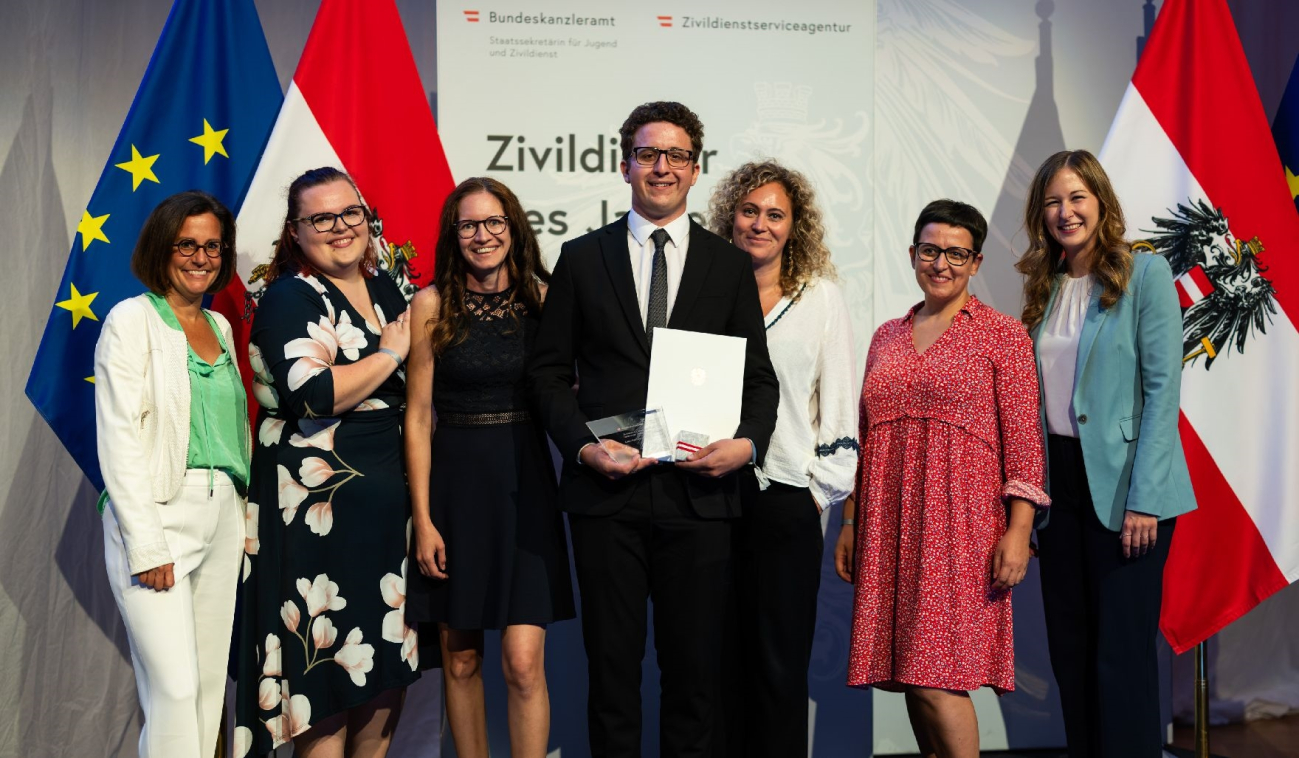 Am 5. September 2024 verlieh Staatssekretärin Claudia Plakolm (r.) im Rahmen einer Festveranstaltung in den Sofiensälen in Wien die Auszeichnung an den “Oberösterreichischen Zivildiener des Jahres 2024” Lorenz Mayrhofer – im Bild mit Diakonie-Direktorin Maria Moser (links) und dem Team der Diakoniewerks-Werkstätte Ried i.d.R.