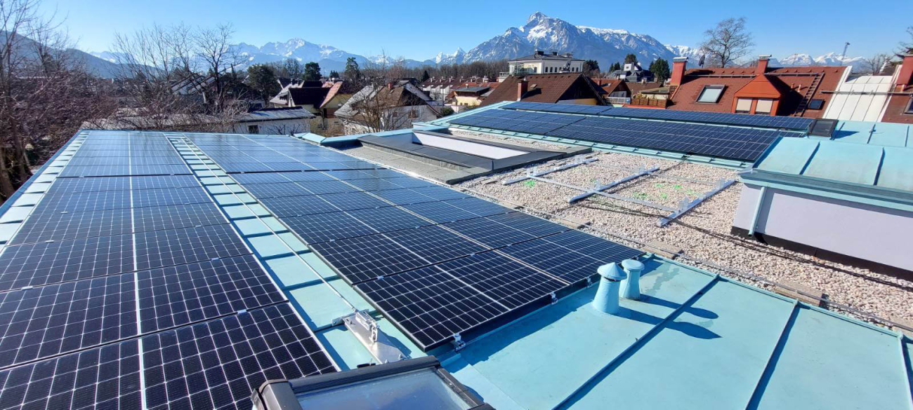 Eine große Photovoltaikanlage auf einem flachen Hausdach.