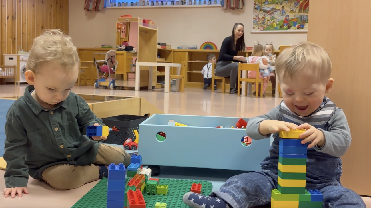 Mit Bauklötzchen spielende Kinder in einer integrativen Krabbelstube.