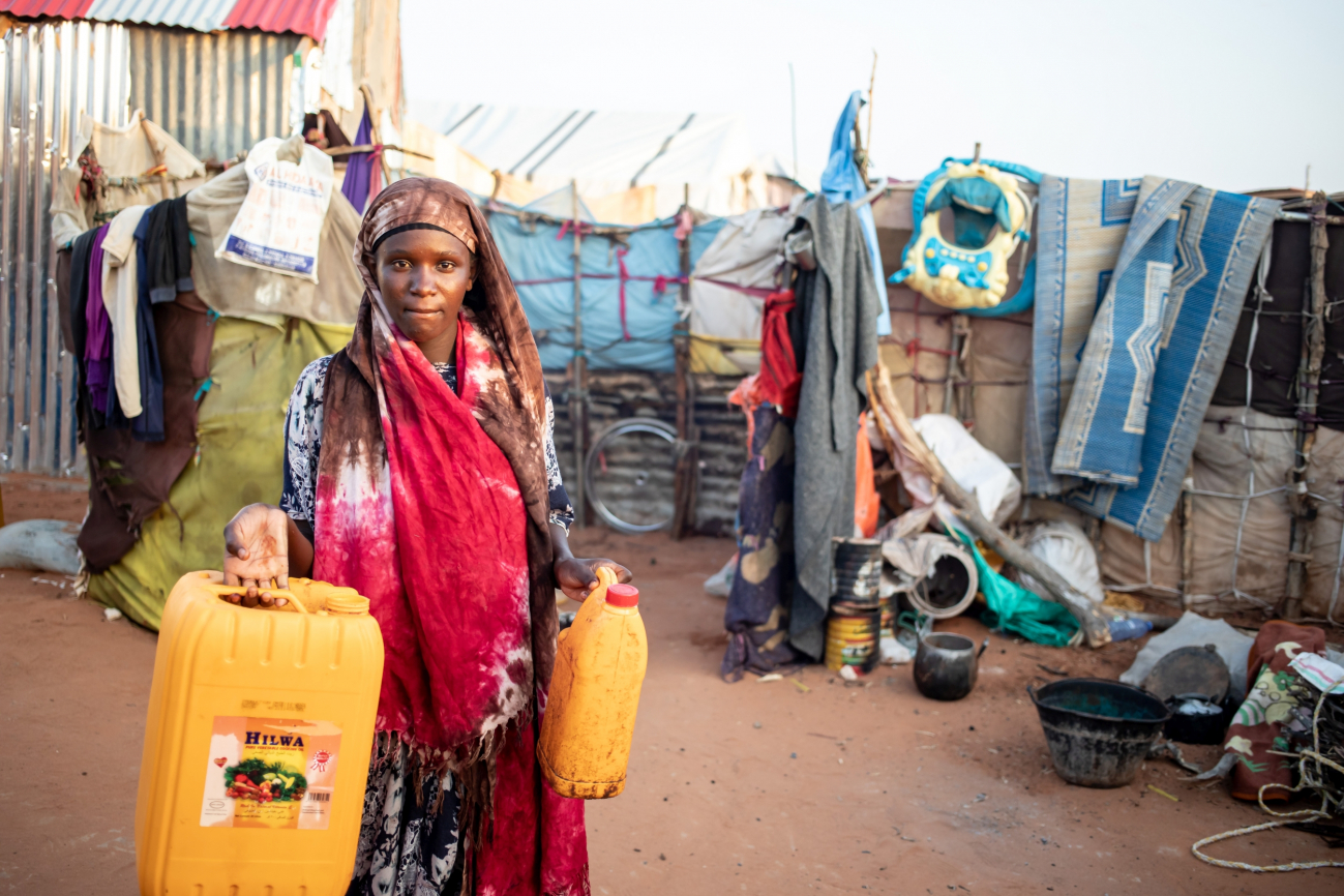 Frau mit leeren Wasserkanistern in einem Lager in Somalia, sie musste aufgrund der Dürre flüchten.