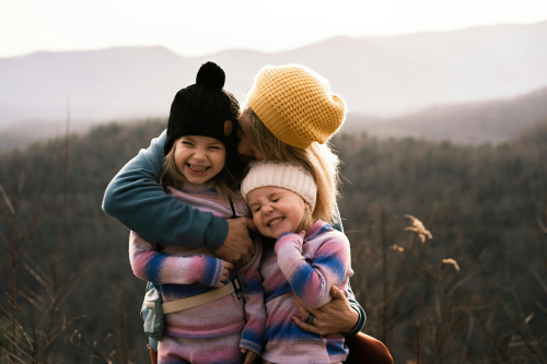 Eine Mutter umarmt ihre beiden Kinder