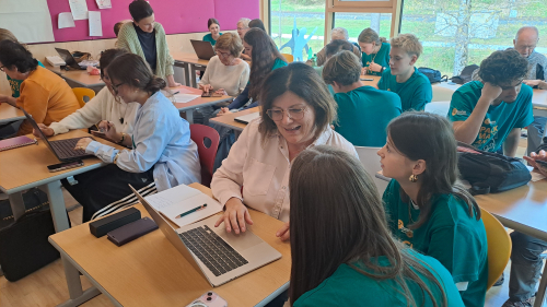 Schülerin und Seniorin sitzen gemeinsam vor einem Smartphone