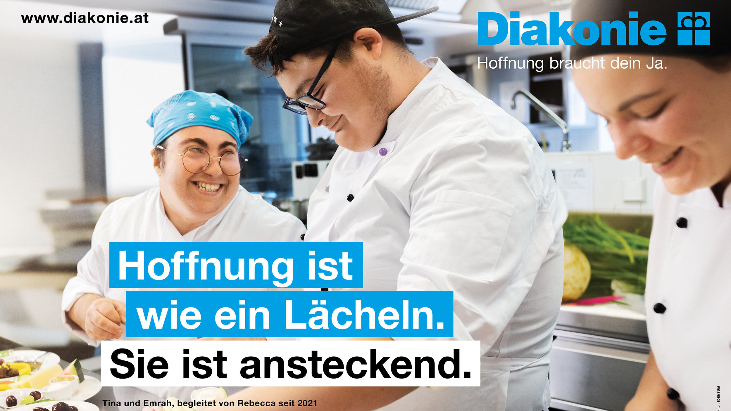 Drei Köch:innen lachen gemeinsam in einer Großküche.