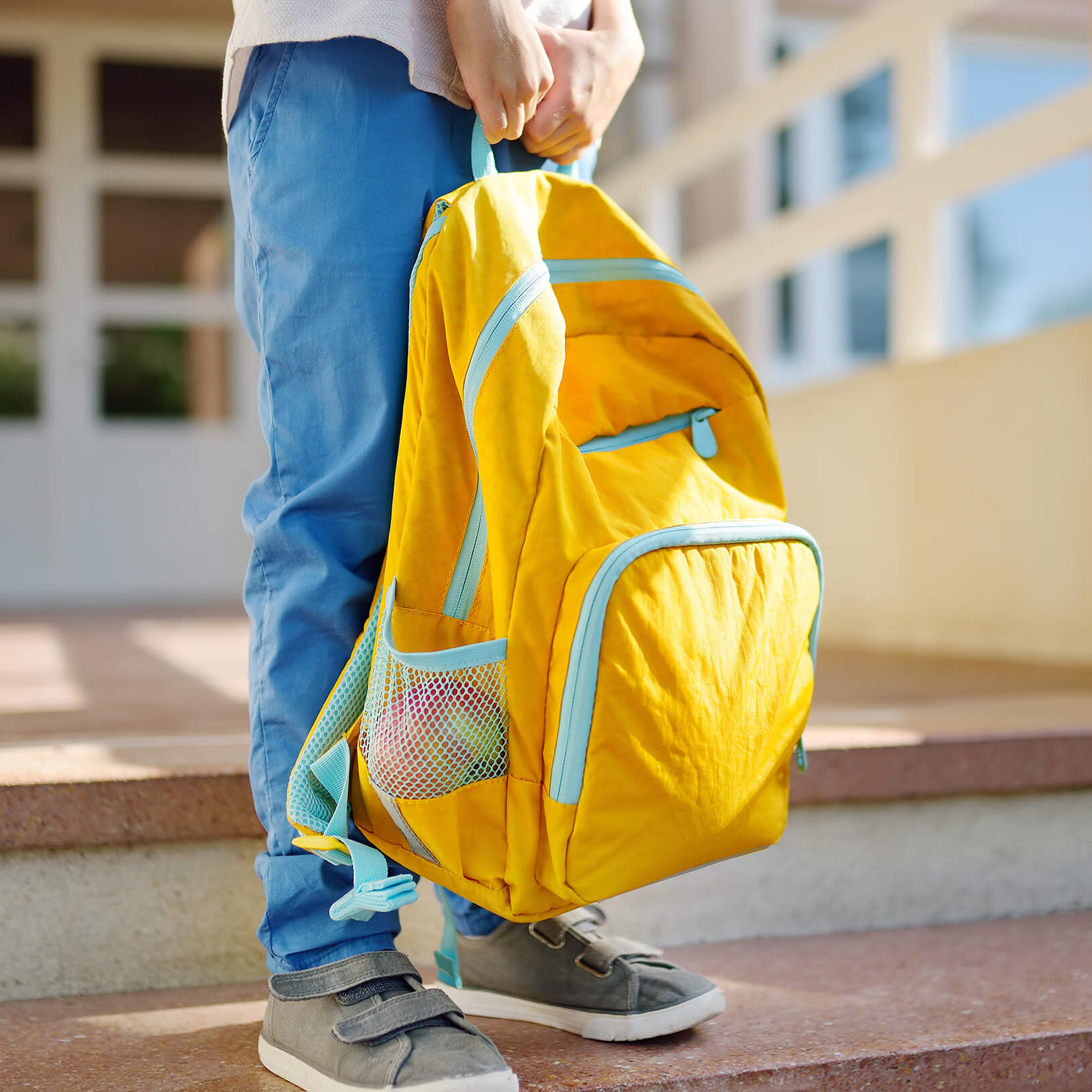 Ein Bub mit einer Schultasche.