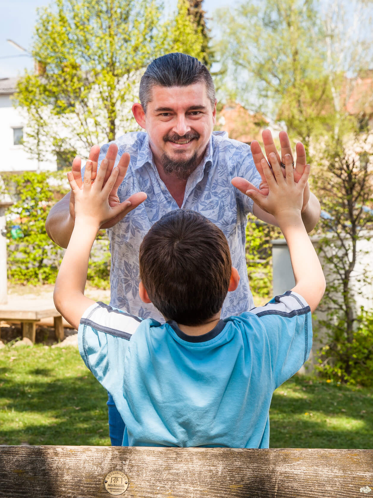 Ein Kind und ein Mitarbeiter der Diakonie klatschen einander in die Hände.