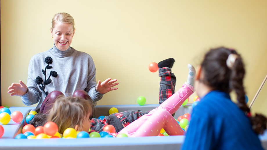 Eine Pädagogin der Spielgruppe Smile spielt im Bällebad mit Kindern