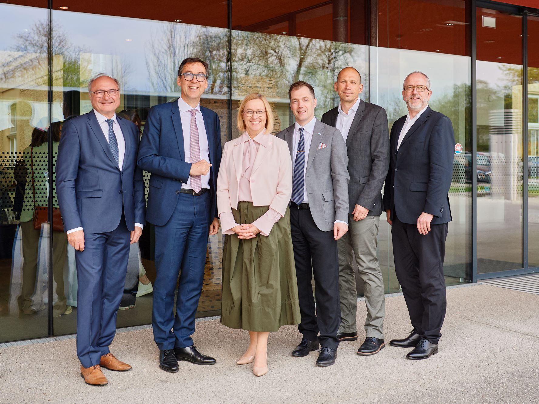 Sechs Personen vor einer Glaswand