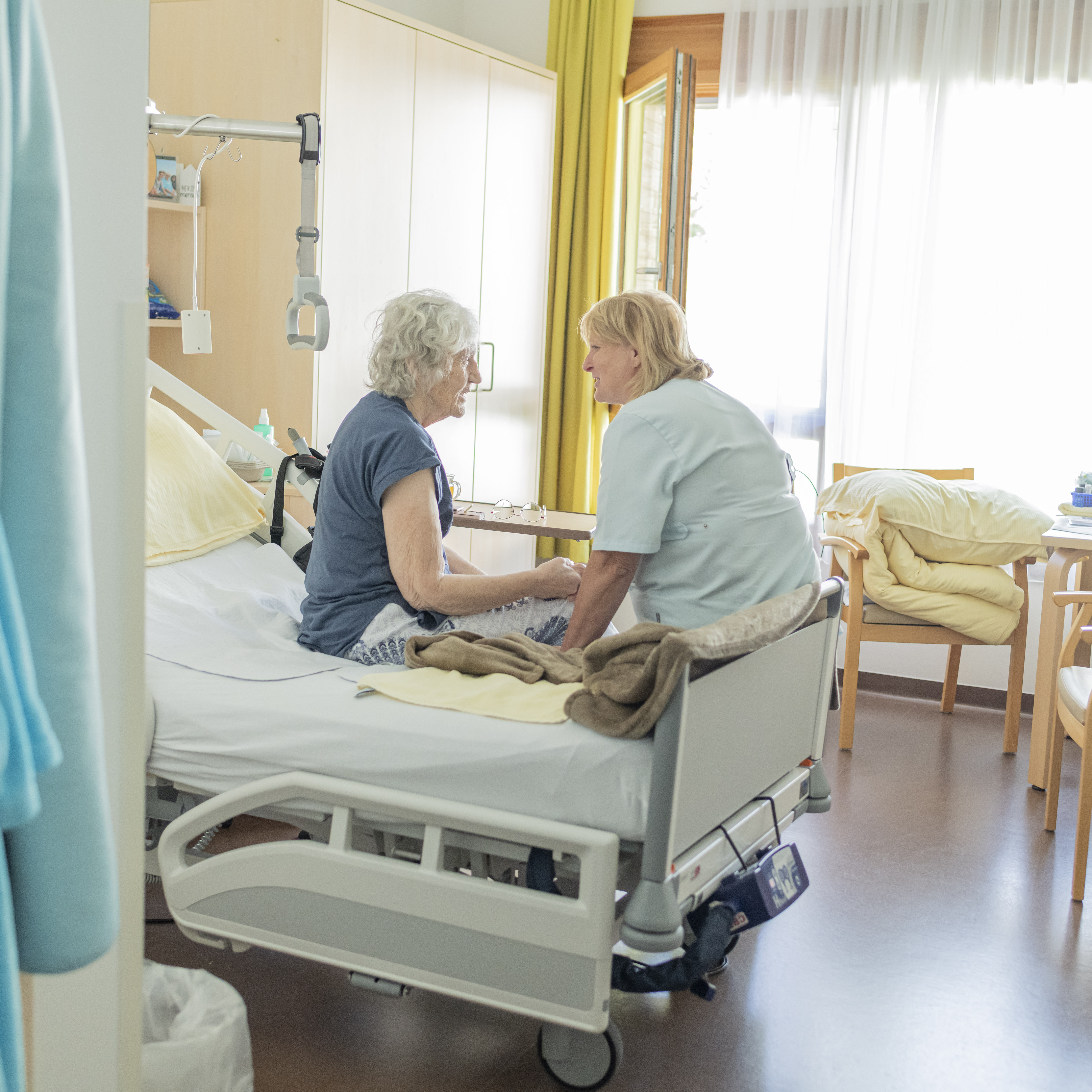 Die Pflegedienstleitung des Diakonie Hospiz Treffen im Gespräch mit einer Dame, die im Hospiz lebt