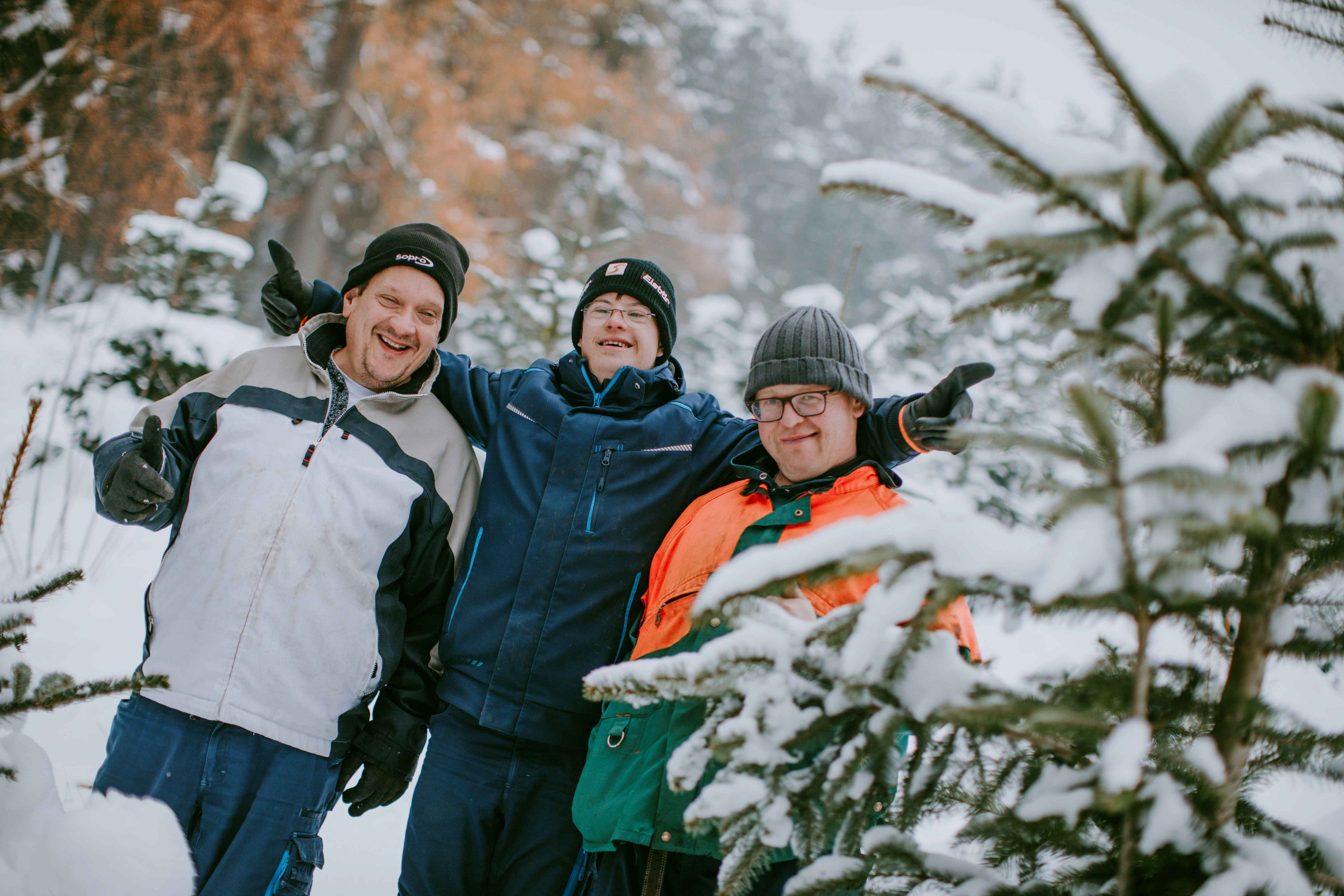 Drei Mitarbeiter im verschneiten Weihnachtswald von Garten & Landschaft
