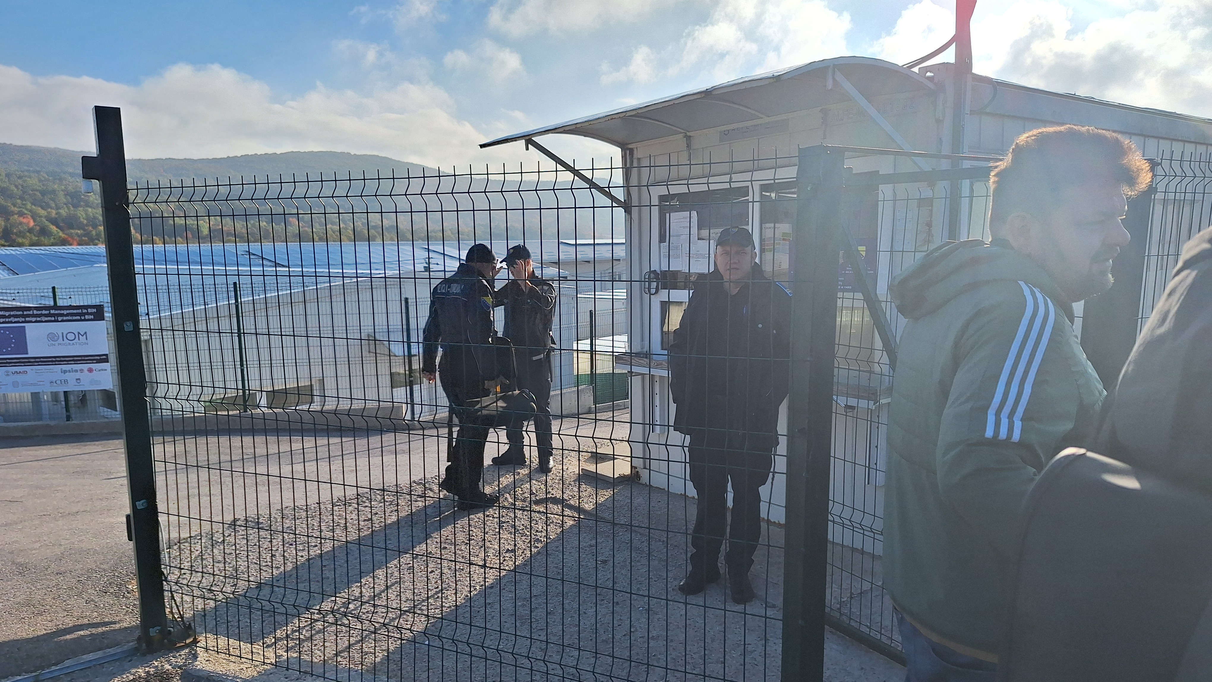 Ein Zaun, Polizisten und ein Grenzhaus an der bosnisch-kroatischen Grenze