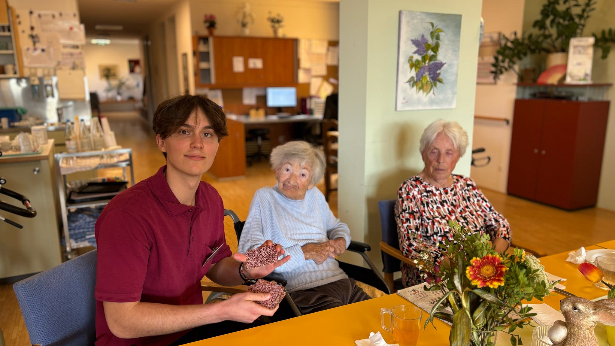 Zivildiener Kevin Schmidt spielt mit Senior:innen im Haus am Ruckerlberg Karten