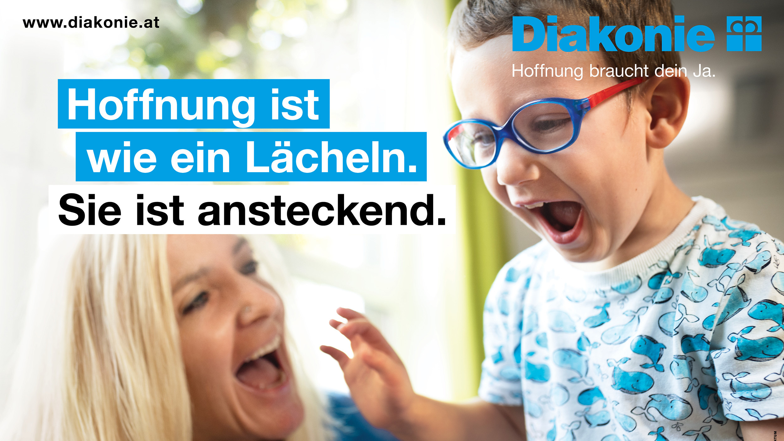 Eine Kindergärtnerin und ein Kind lachen miteinander.