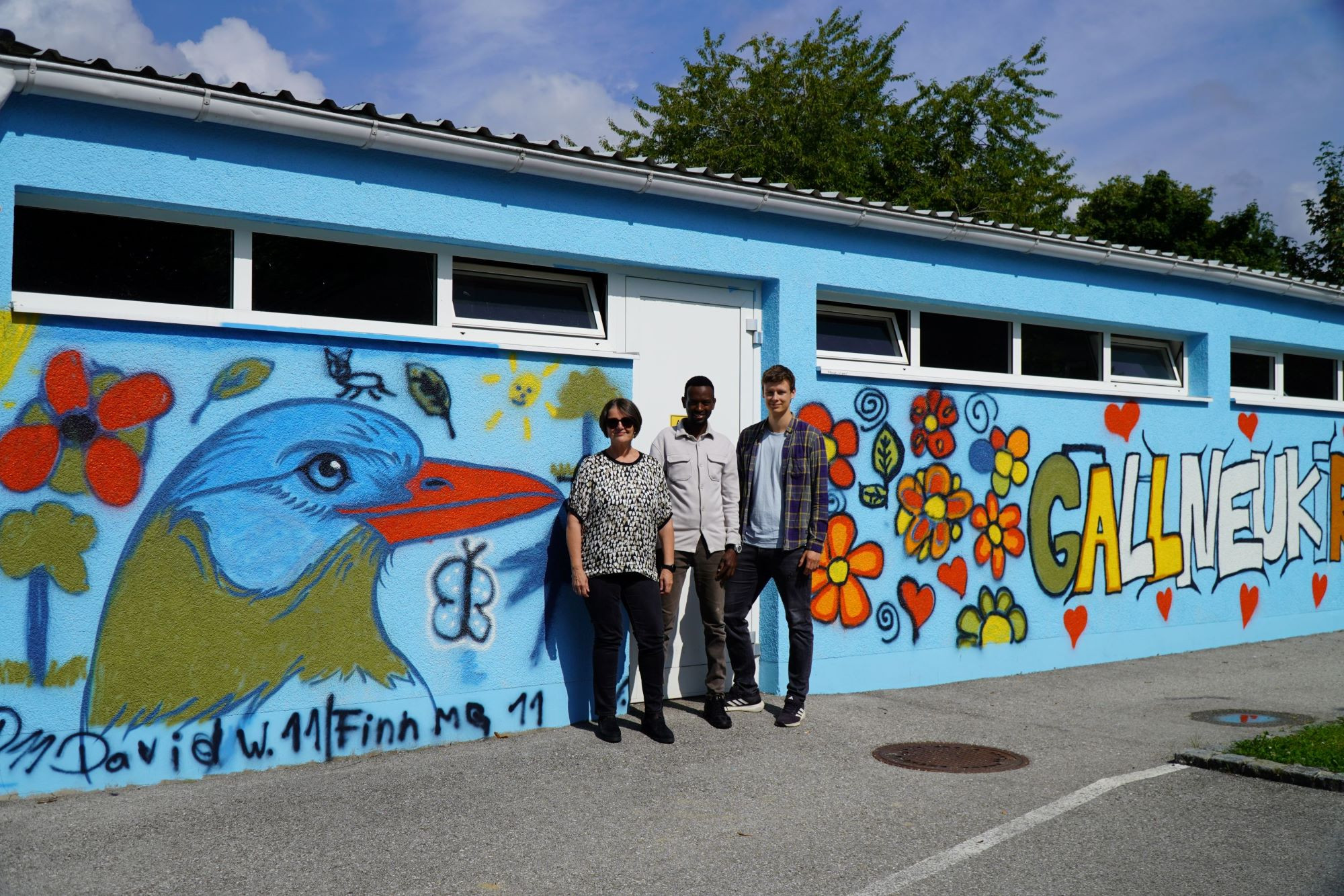 Drei Personen vor dem Graffiti-Wandbild "Unsere Spuren" in Gallneukirchen