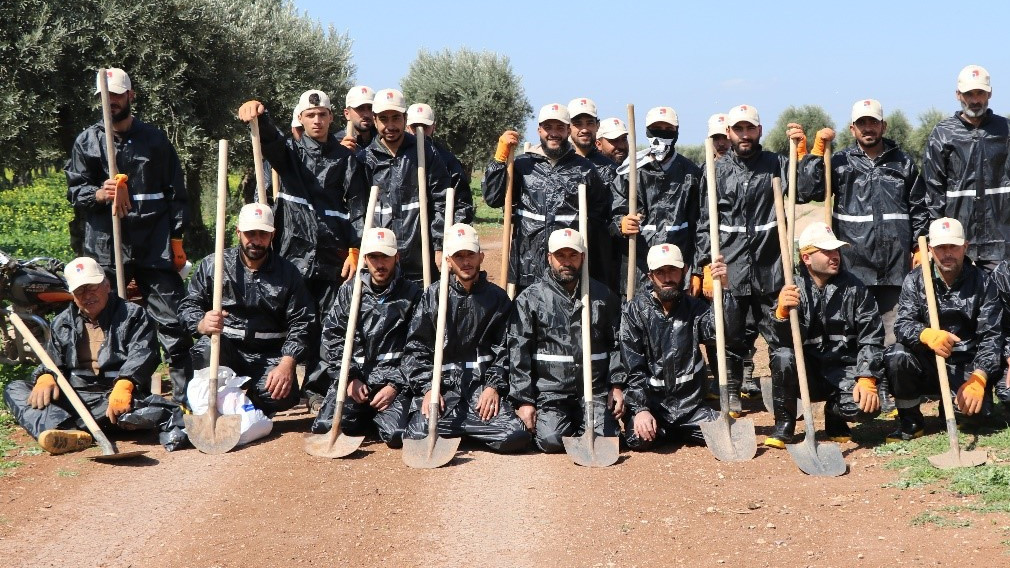 Gruppe von Männern im Arbeitsgewand mit Schaufeln in der Hand