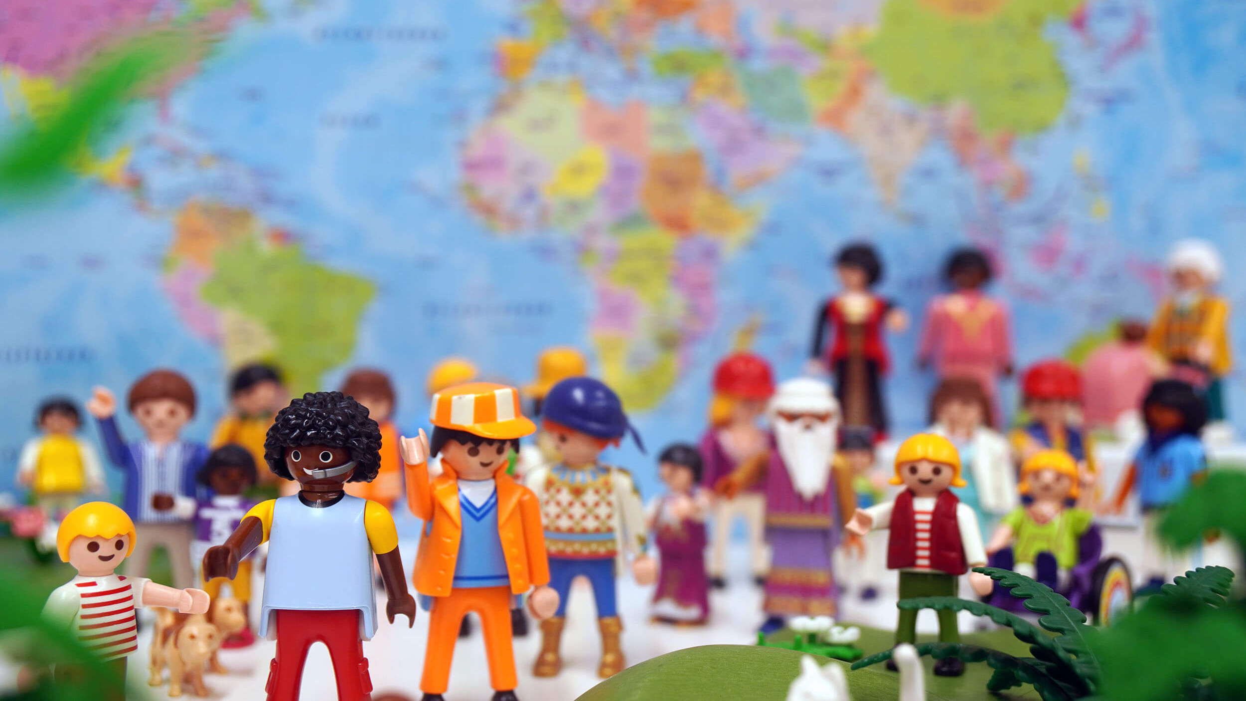 Foto von Playmobil-Figuren vor einer Weltkarte