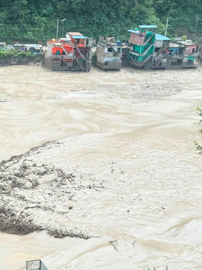 Nepal: Wassermassen, Häuser im Hintergrund
