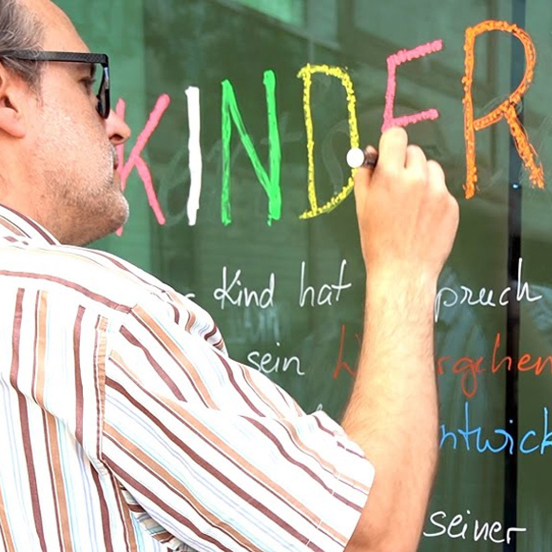 Kinderrechte werden an eine Fensterscheibe geschrieben.