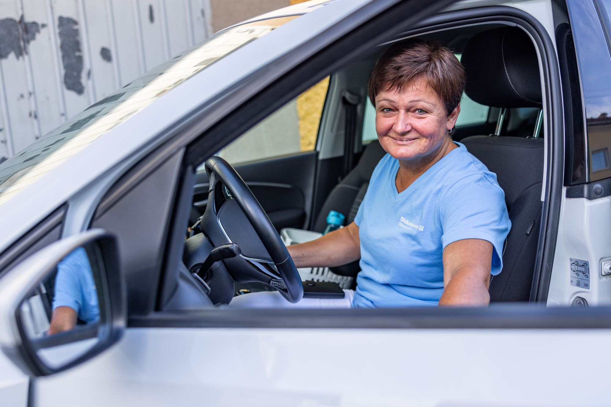 Frau in Auto zur mobilen Pflege