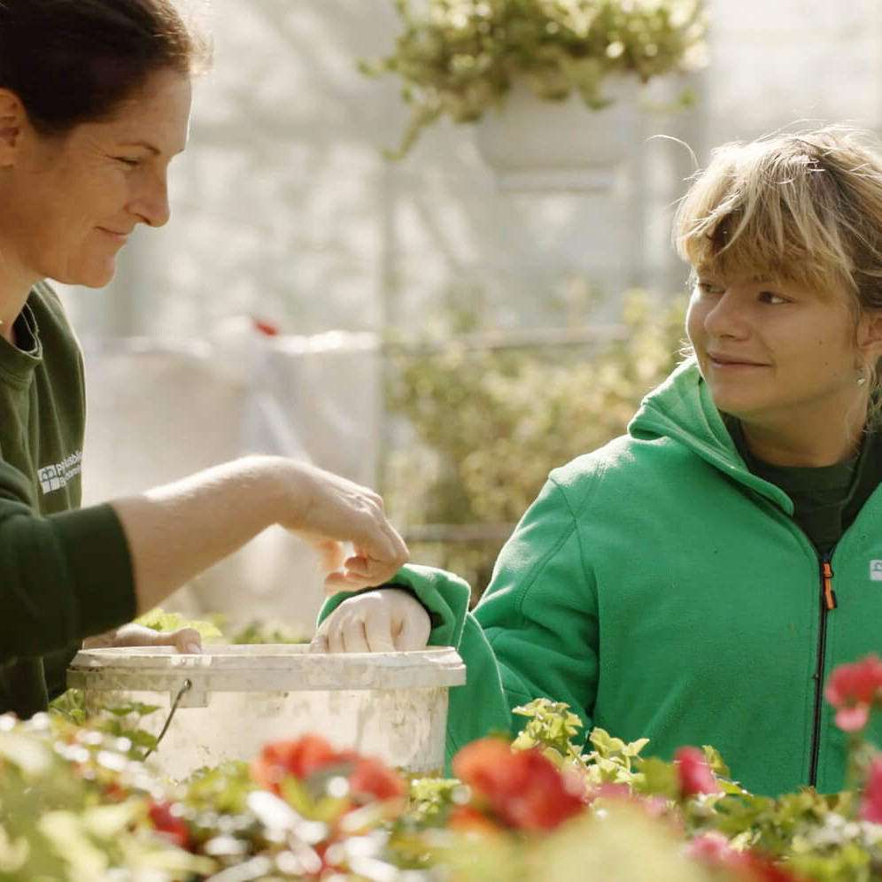 Zwei Frauen bei der Arbeit in einer Gärtnerei.