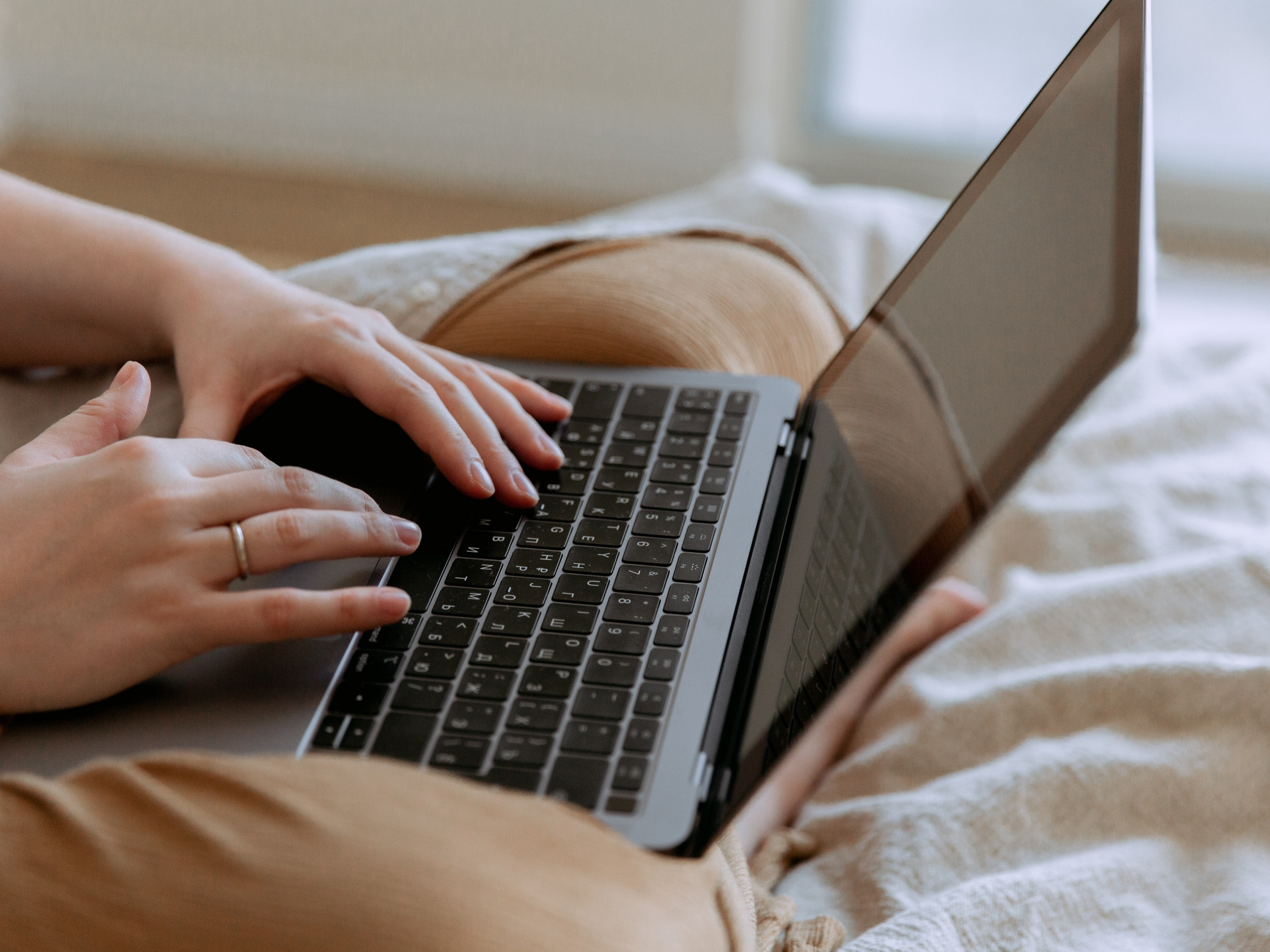 Sitzende Frau mit Laptop am Schoß
