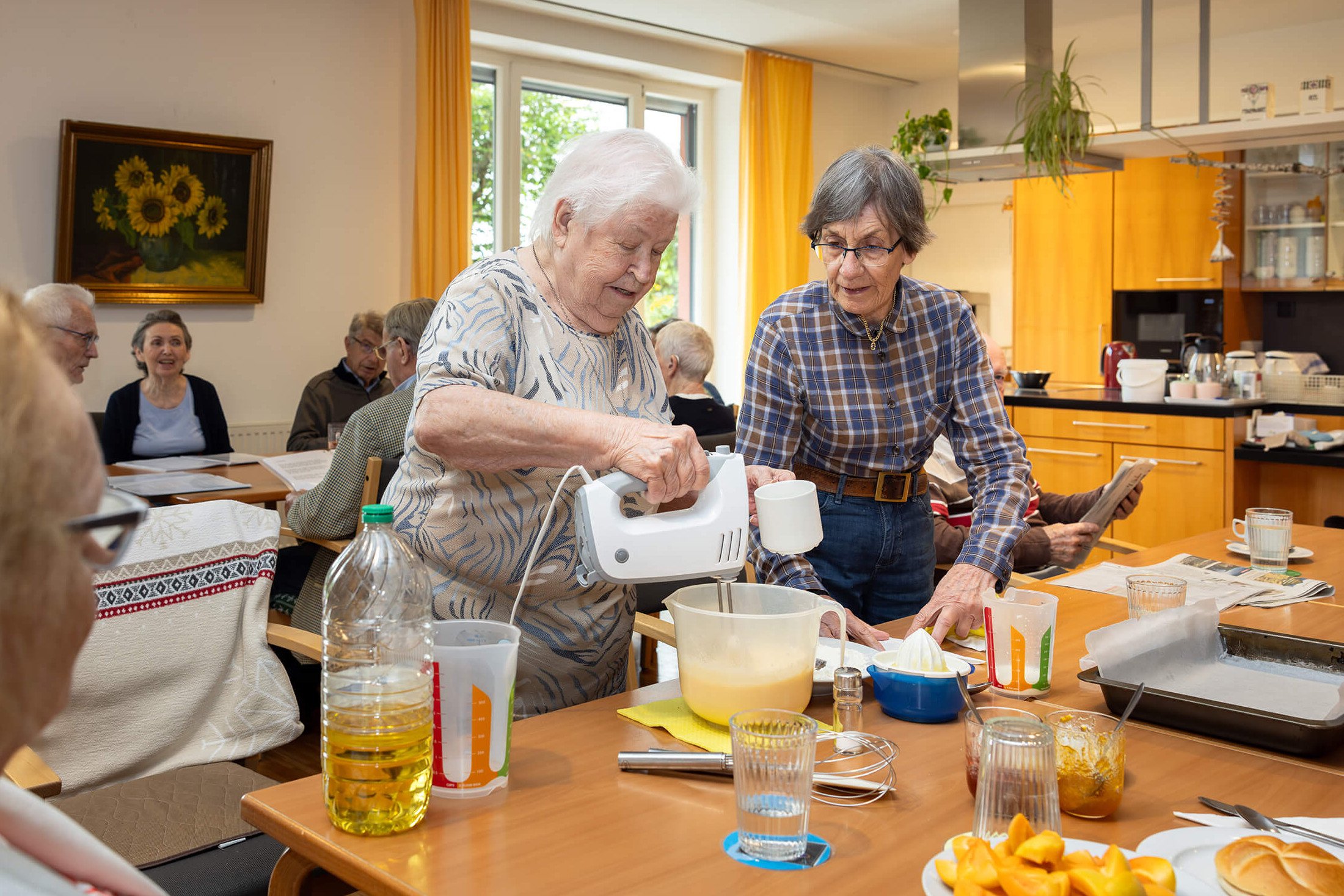 Seniorenbetreuerin Elisabeth Müller bedient Handmixer in einem Gemeinschaftsraum in Wien
