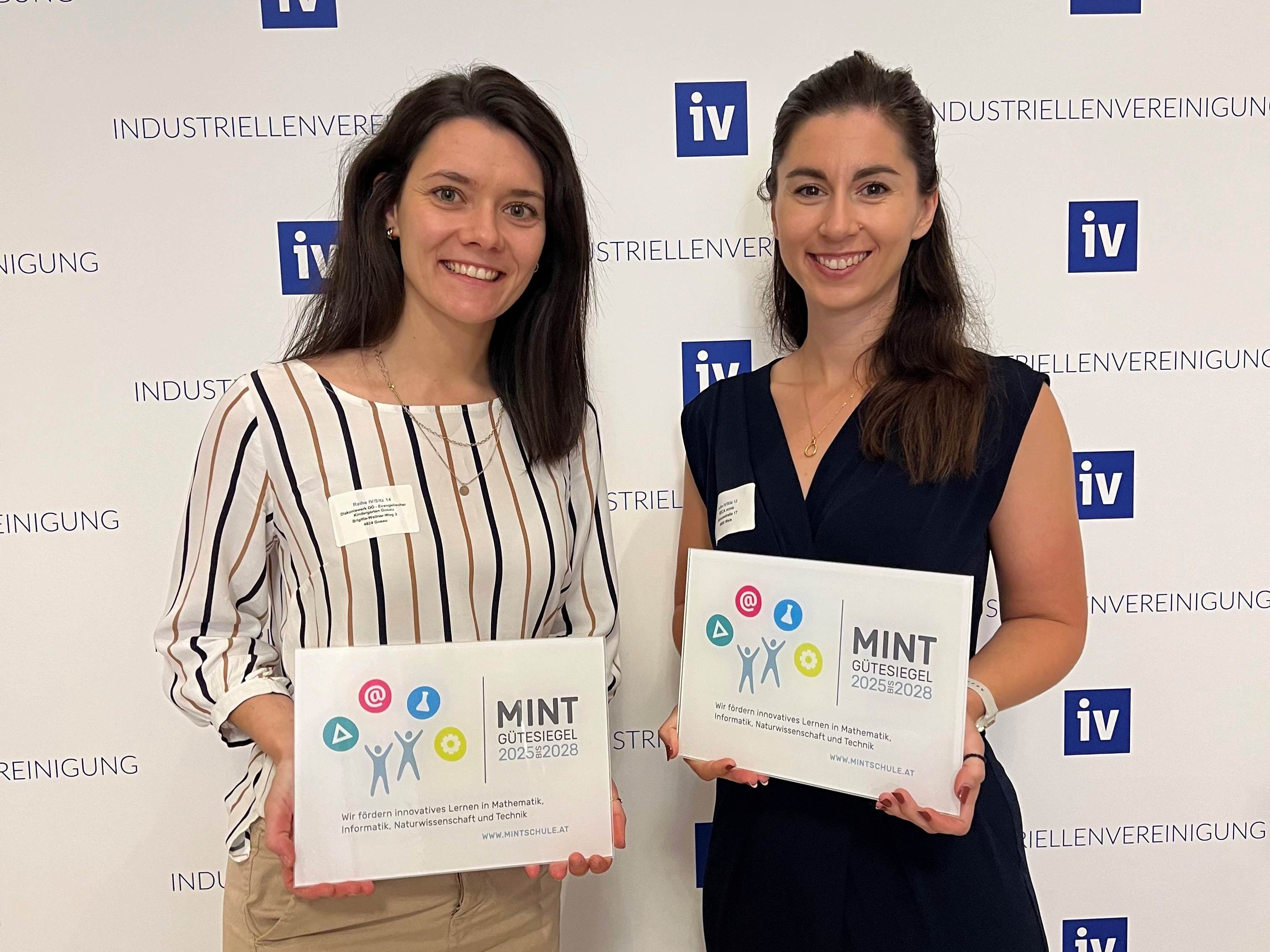 Silke Reisenauer und Tanja Hable übernehmen stolz die MINT-Auszeichnung für die Kindergärten RECA minis und Gosau.