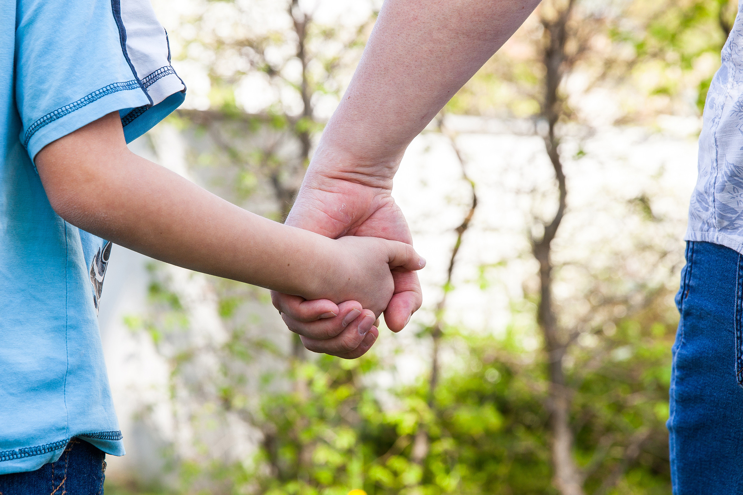 Eine Erwachsenenhand hält eine Kinderhand.