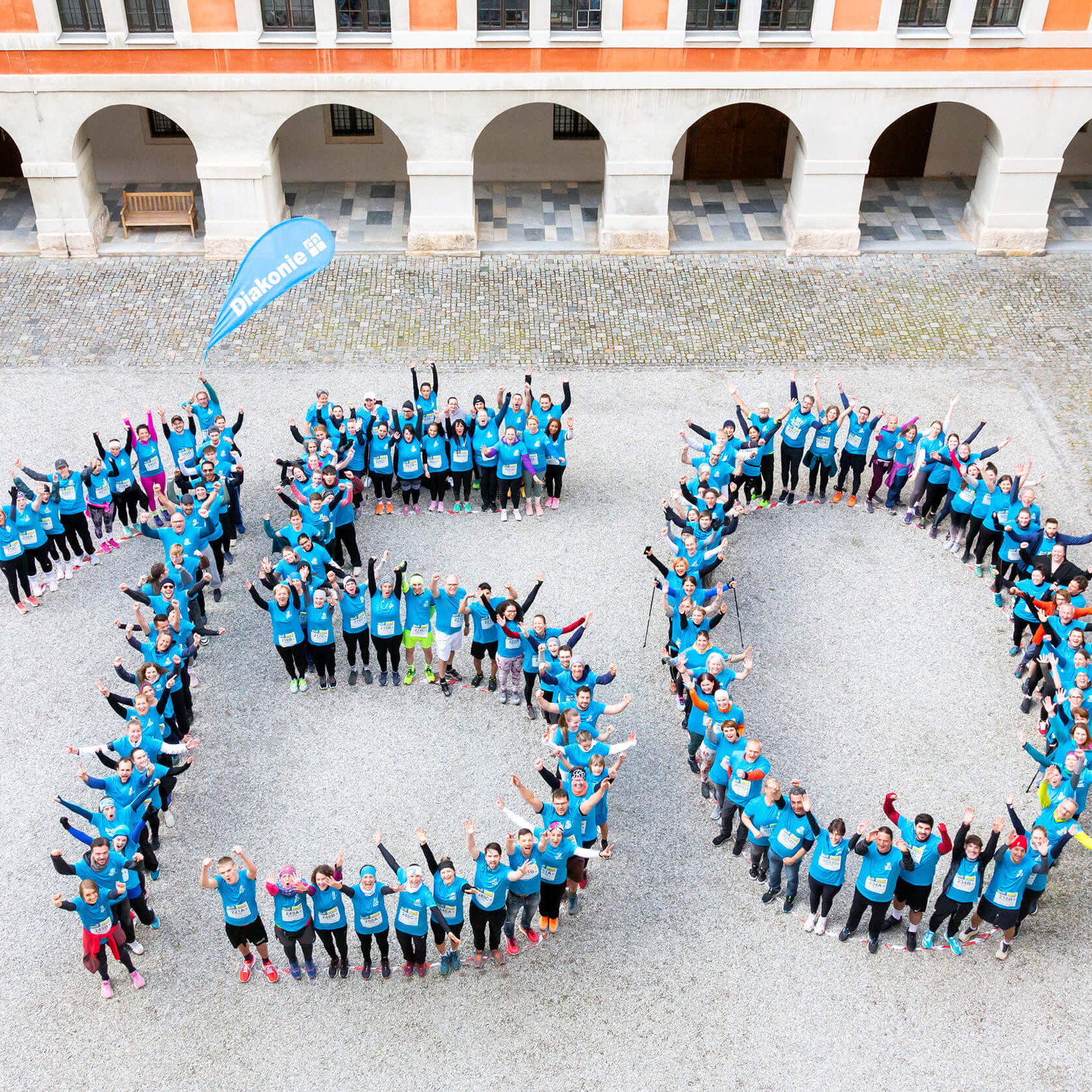 Läufer:innen am Business Run in Graz bilden eine große 150.