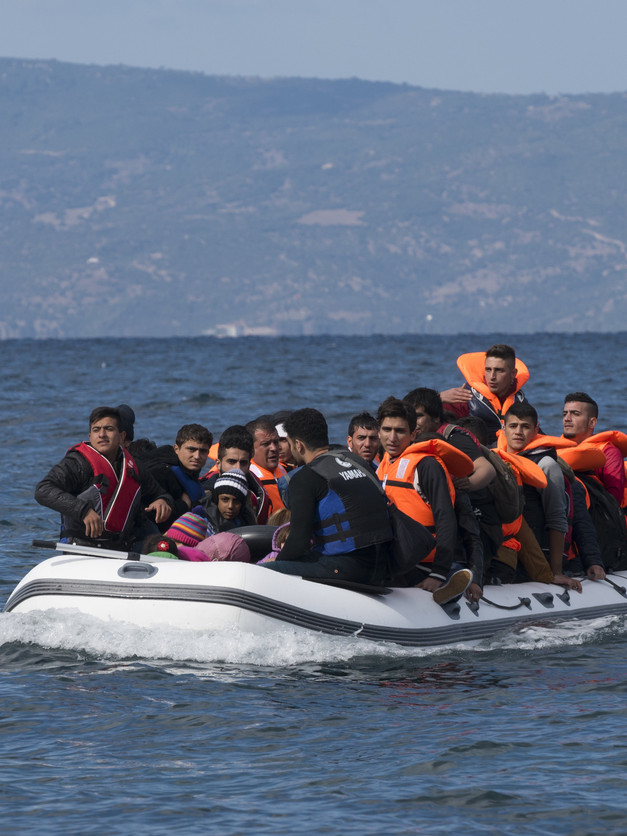 Menschen in einem Boot auf dem Meer, fast alle tragen Schwimmwesten.