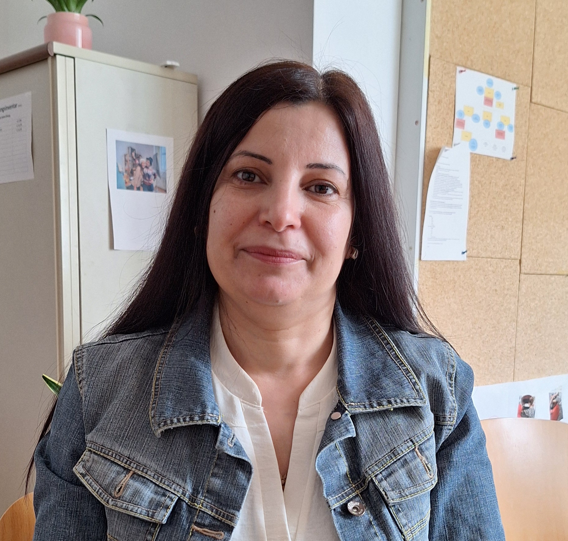 Frau sitzt auf einem Stuhl und schaut in die Kamera