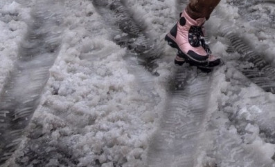 Menschen gehen im Schnee. Man sieht nur die Beine.