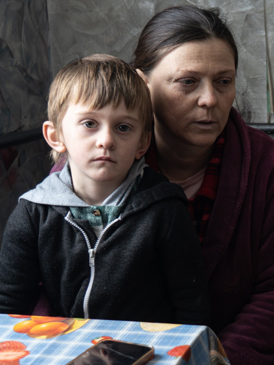 Eine Frau sitzt mit zwei Kindern auf einem Sofa.