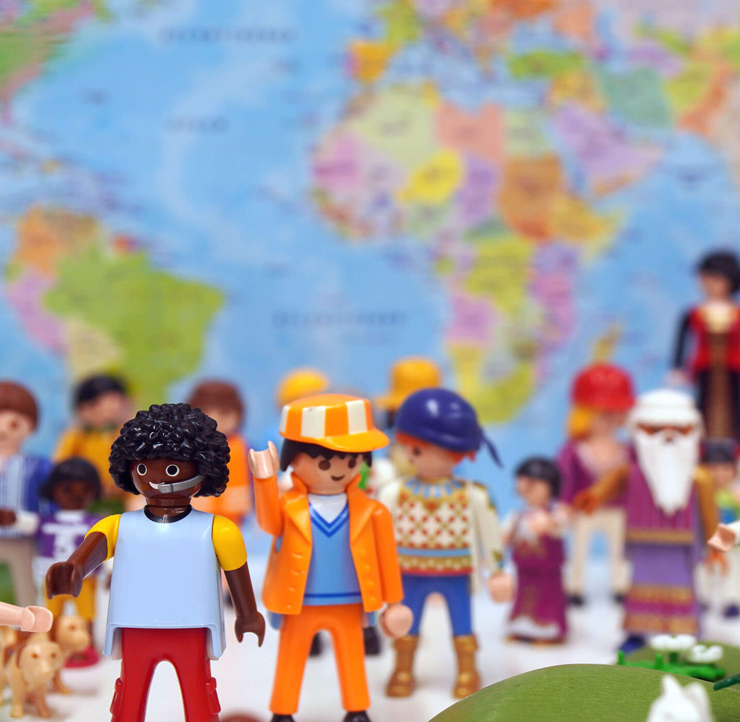 Foto von Playmobil-Figuren vor einer Weltkarte