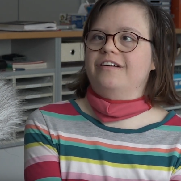 Frau mit Brille und Hals-Tuch spricht in ein Mikrofon