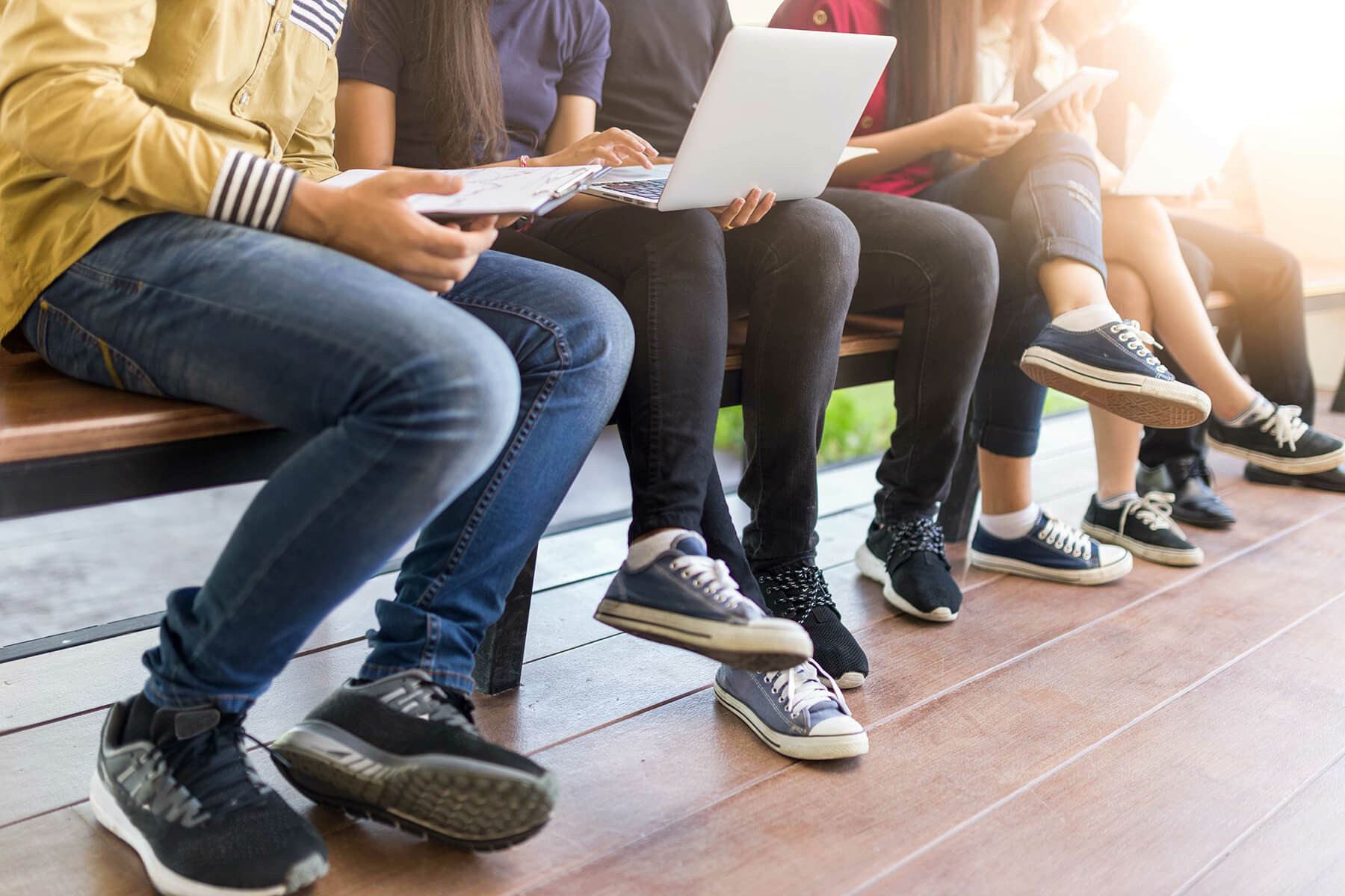 Mehrere Schüler:innen auf einer Bank.