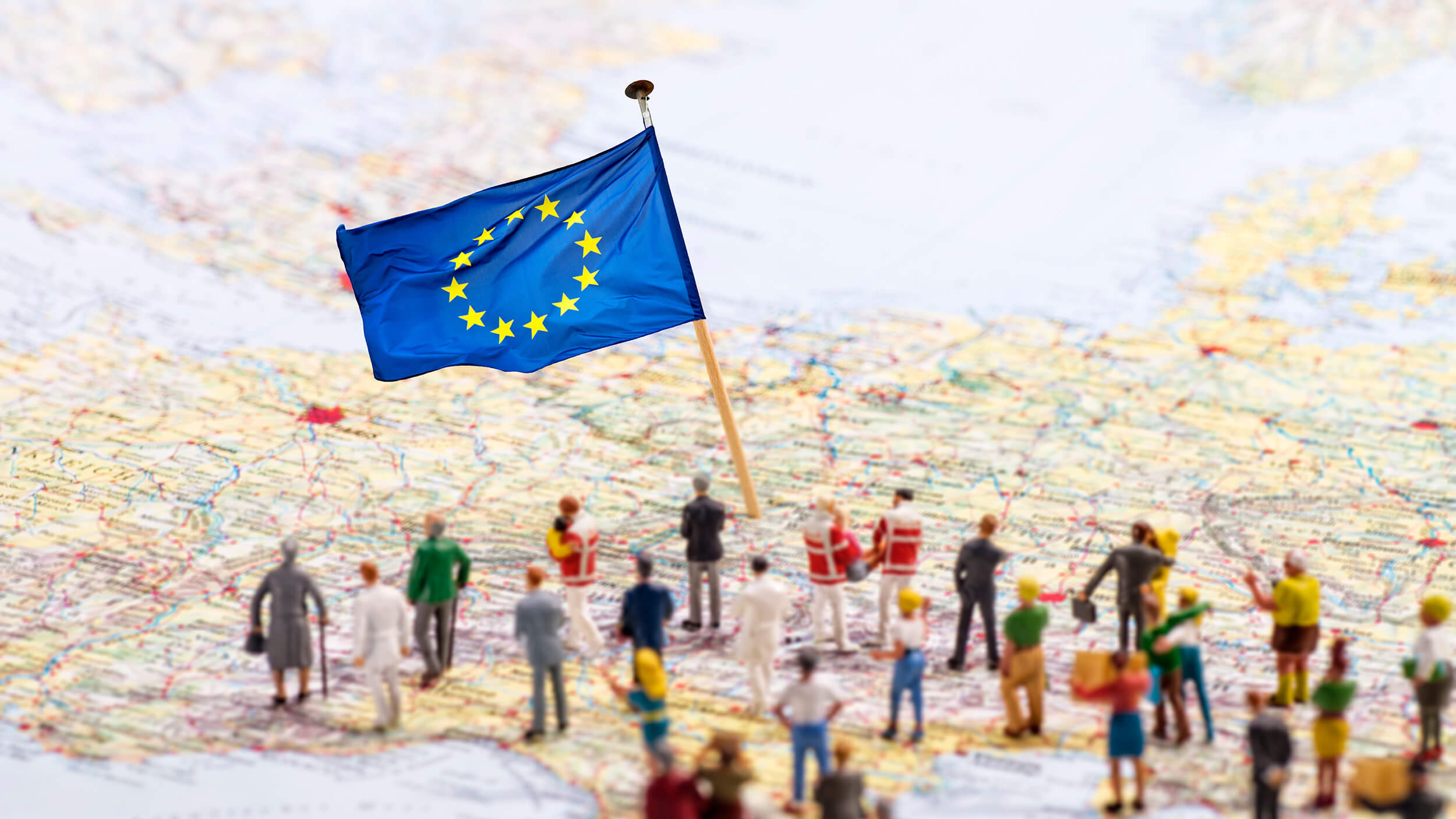 Eine Karte von Europa mit einer kleinen EU-Flagge und kleinen Spielfiguren.