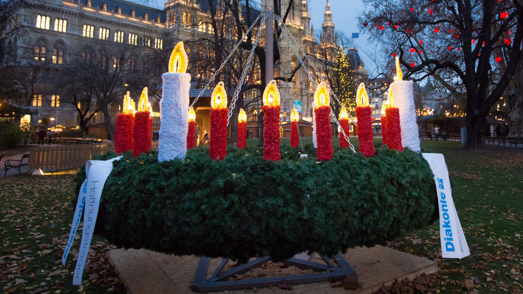 Ein großer Diakonie-Adventkranz mit vielen elektrischen Kerzen am Rathhausplatz in Wien.