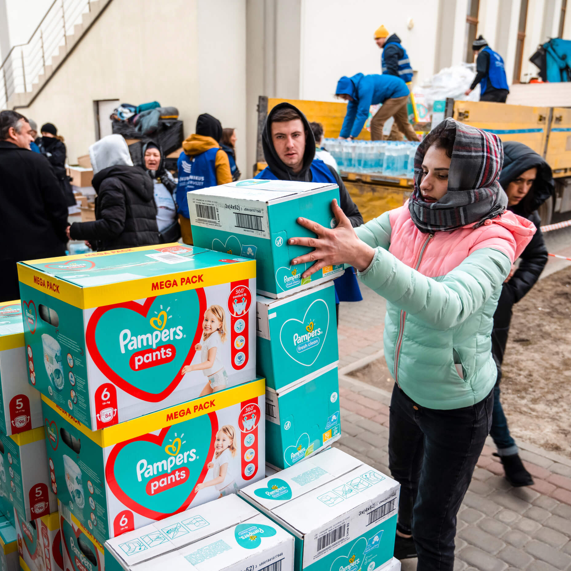 Mitarbeiterinnen und Mitarbeiter der Diakonie Katastrophenhilfe Partnerorganisation Hungarian Intercurch Aid verteilen Windeln und andere Güter.