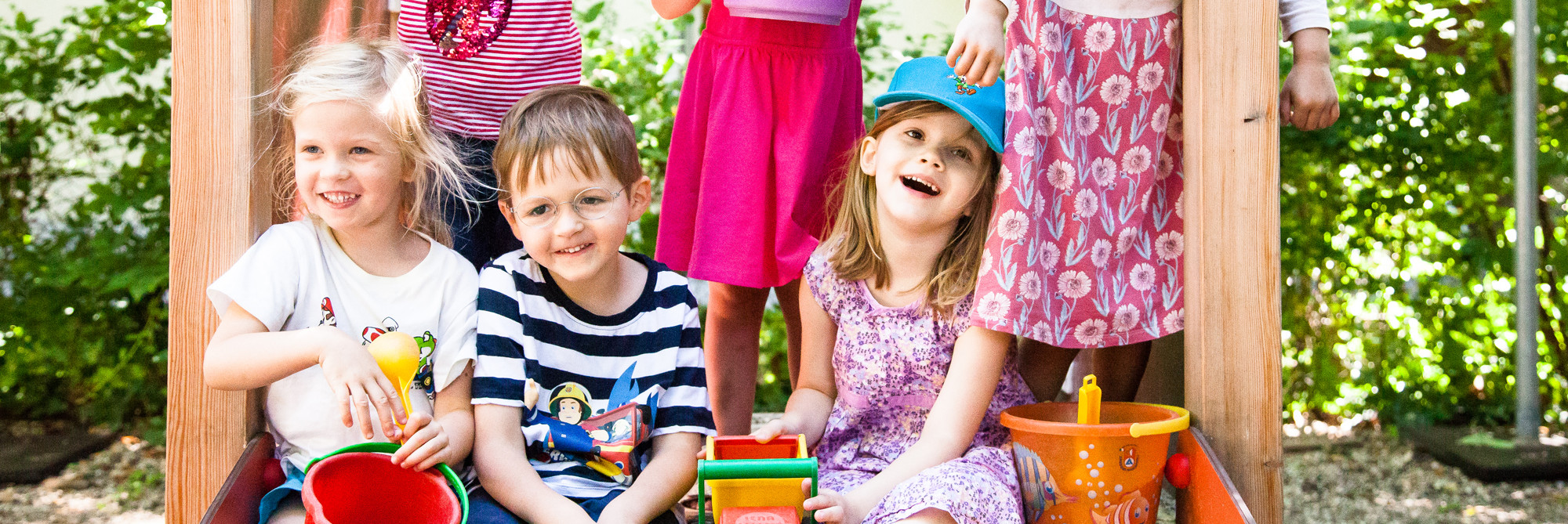 Kinder auf Rutsche im Garten