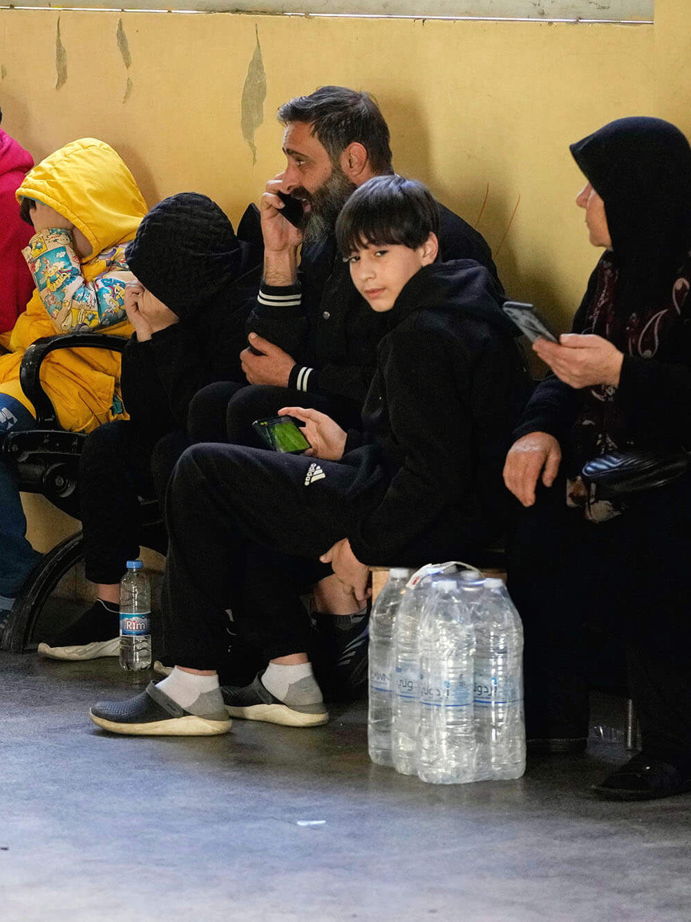 Families displaced by Israeli airstrikes in southern Lebanon and Dahiyeh, Beirut's southern suburbs, sit inside a school used as a shelter in Beirut, Lebanon, Monday, March 9, 2026. (AP Photo/Hassan Ammar)
