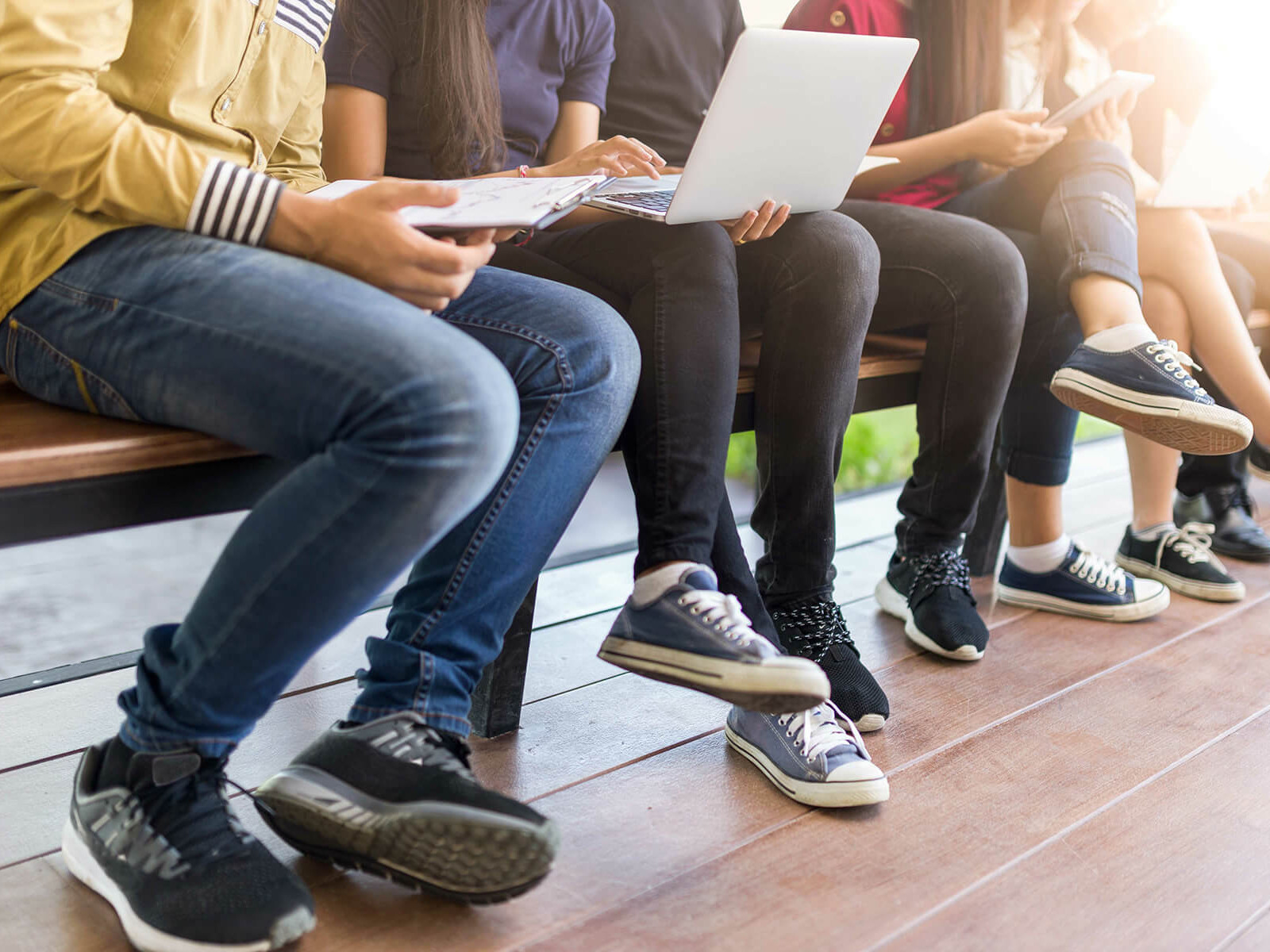 Mehrere Schüler:innen auf einer Bank.