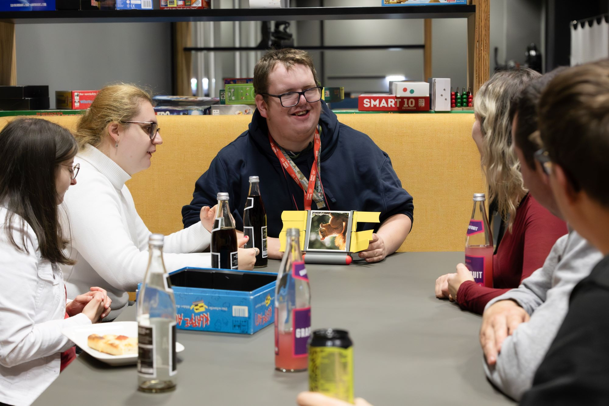 Gruppe von Jugendlichen, die an einem Tisch Gesellschaftsspiele spielen