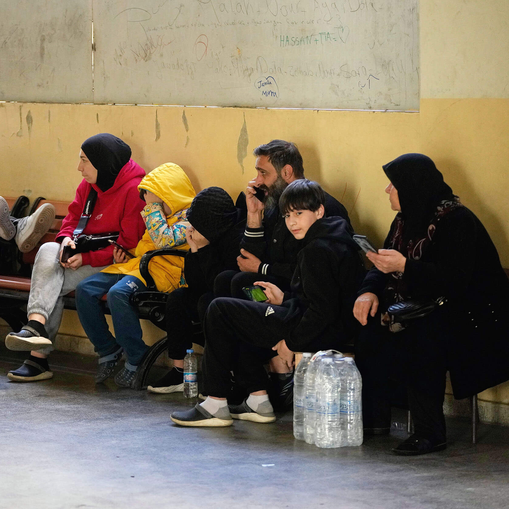 Families displaced by Israeli airstrikes in southern Lebanon and Dahiyeh, Beirut's southern suburbs, sit inside a school used as a shelter in Beirut, Lebanon, Monday, March 9, 2026. (AP Photo/Hassan Ammar)
