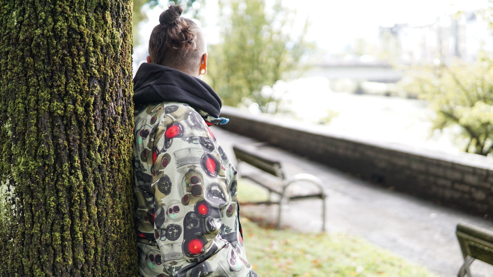 Junge Person an einen Baum gelehnt.